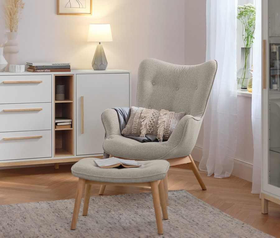 Tischleuchte mit Keramikfuß steht auf einer weißen Kommode im Wohnzimmer.