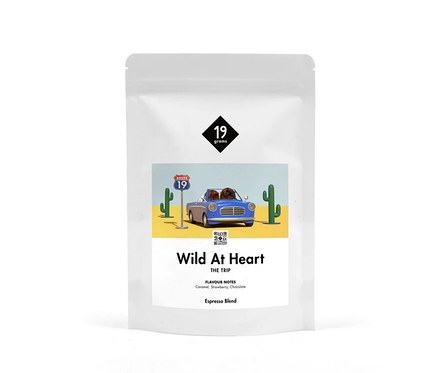 Weiße Verpackung von 19grams Wild at Heart Espresso ganze Bohne mit einer Illustration einer Wüstenlandschaft mit blauem Auto.