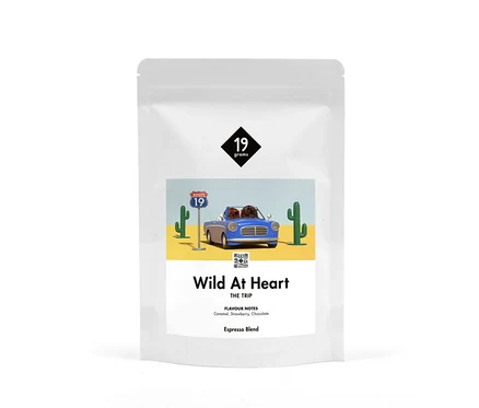 Weiße Verpackung von 19grams Wild at Heart Espresso ganze Bohne mit einer Illustration einer Wüstenlandschaft mit blauem Auto.
