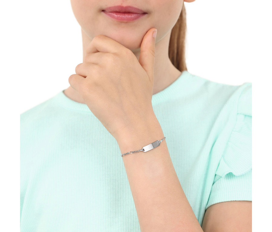 Eine Person trägt ein hellblaues Oberteil und ein silbernes Armband mit Gravurplatte am Handgelenk. Eine Hand ruht am Kinn.