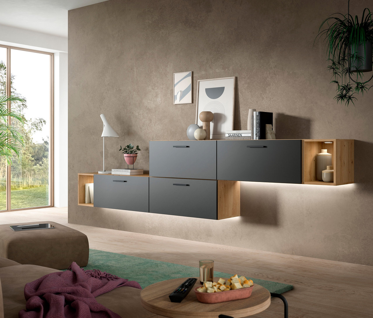 Graue xonox Wohnkombination »Only« inkl. Beleuchtung an einer braunen Wand in einem modernen Wohnzimmer. Die Kombination aus grauen Schubladen und offenen Holzfächern ist mit Dekoartikeln, Büchern und einer Lampe bestückt. Im Vordergrund sind ein Sofa und ein Couchtisch zu sehen.