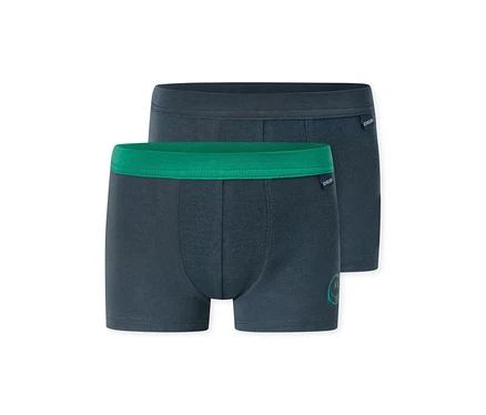 Zwei dunkelblaue Jungen-Boxershorts, eine mit grünem Bund und kleinem grünem Aufdruck, die andere mit dunkelblauem Bund. Beide haben das SCHIESSER-Logo.