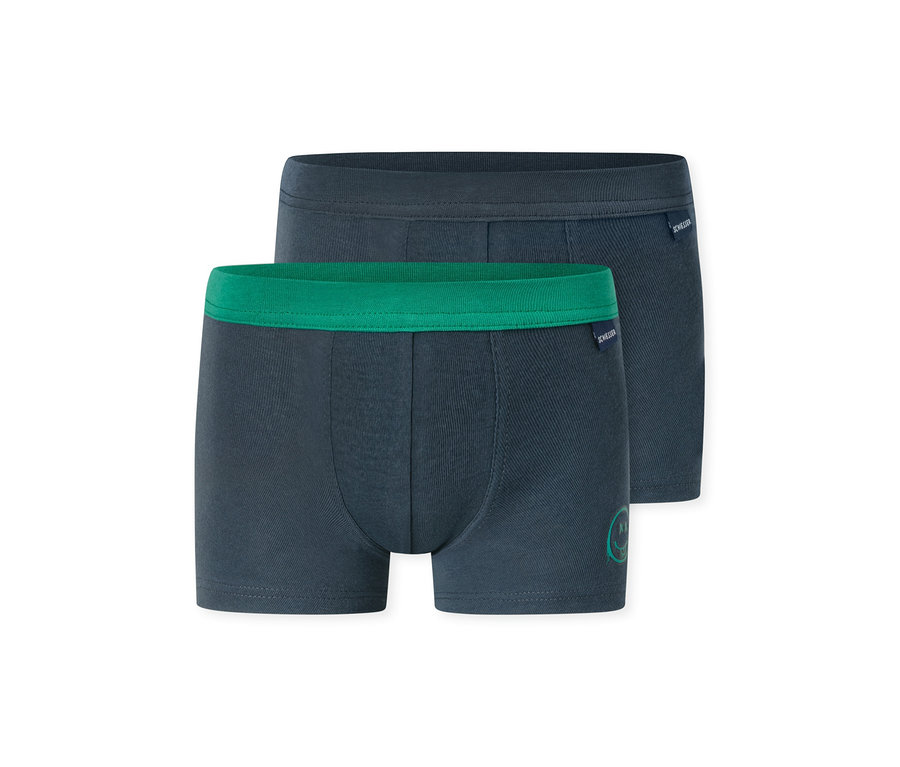 Zwei dunkelblaue Jungen-Boxershorts, eine mit grünem Bund und kleinem grünem Aufdruck, die andere mit dunkelblauem Bund. Beide haben das SCHIESSER-Logo.