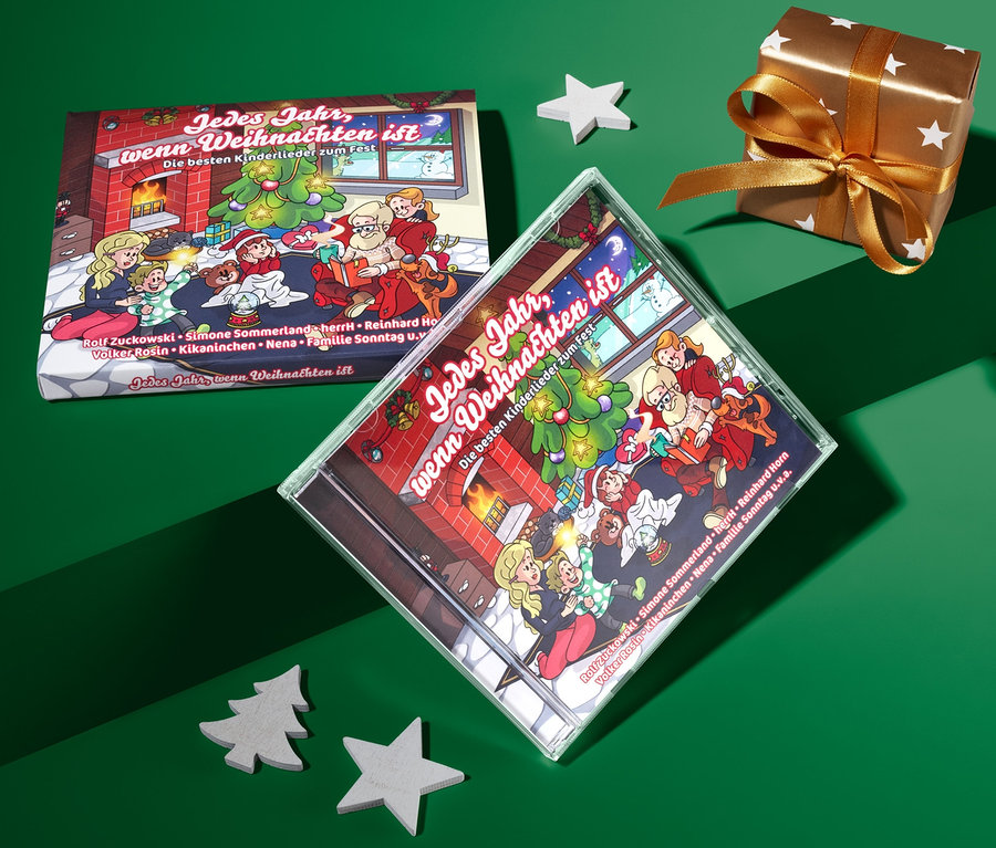 Auf grünem Grund liegen die CD »Jedes Jahr, wenn Weihnachten ist«, ein Geschenk und Dekorationen.