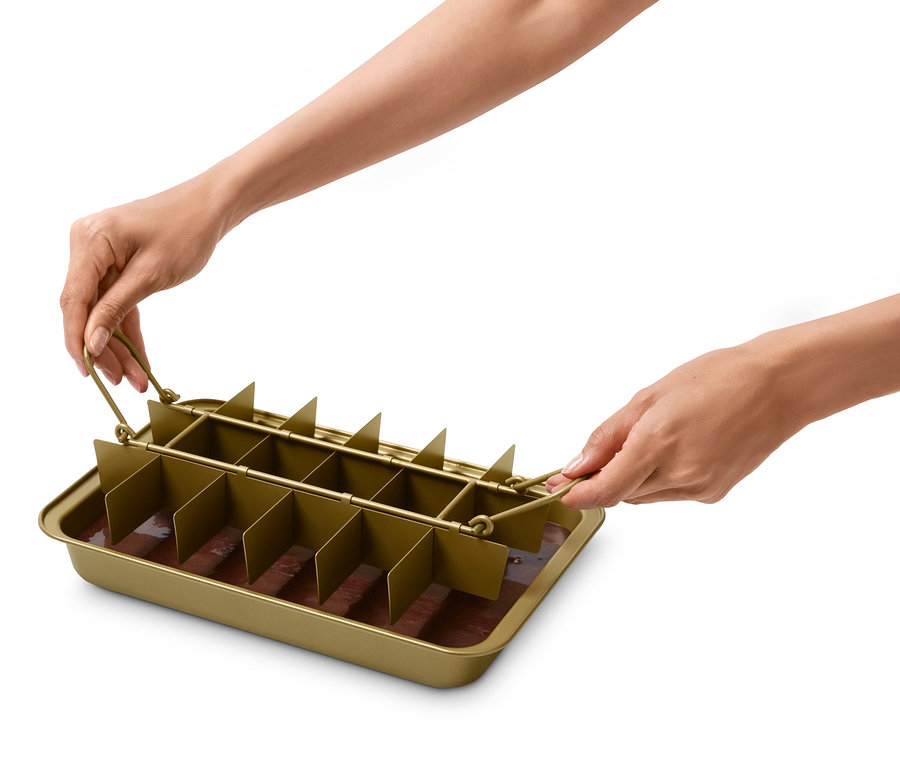 Hände halten eine Brownie-Backform mit einer braunen Mischung darin.