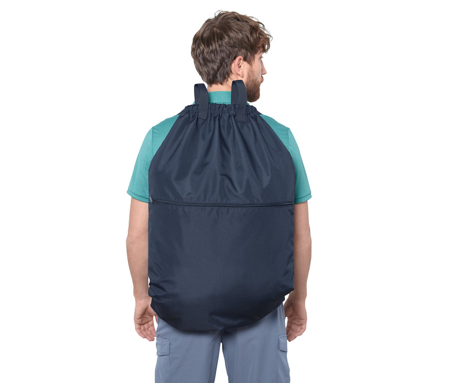 Mann trägt Camping-Wäschesack auf dem Rücken.