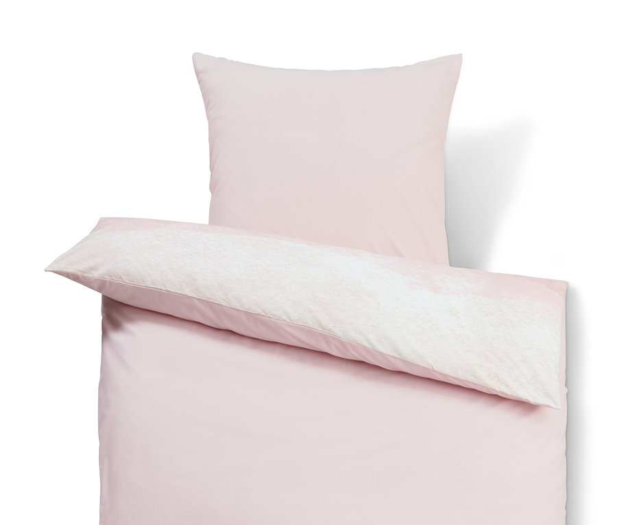 Rosa Renforcé-Bettwäsche und Kissen auf weißem Hintergrund.