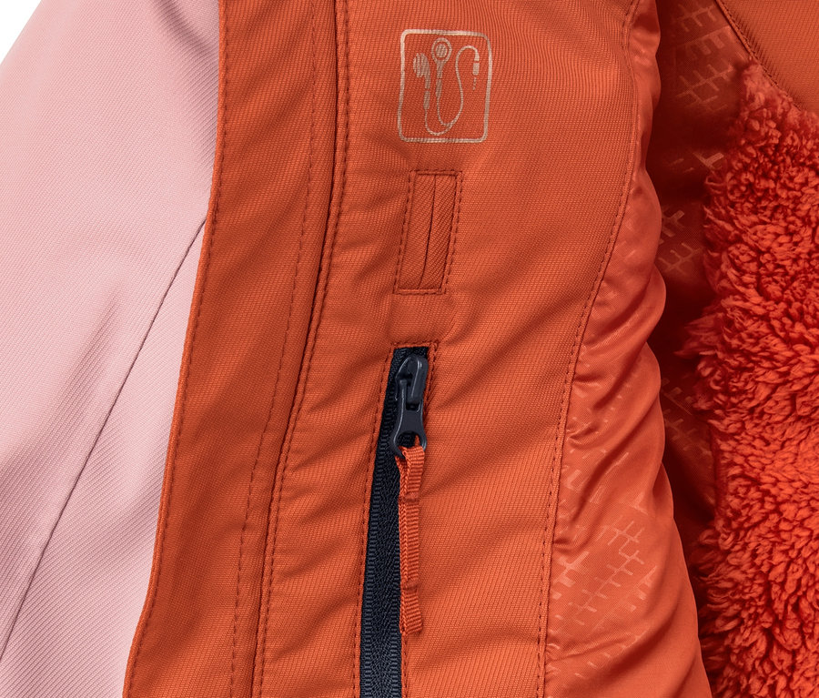 Detailaufnahme einer Ski- und Snowboardjacke im Colorblocking-Design, die einen orangefarbenen Reißverschluss und rosafarbenen Stoff zeigt.