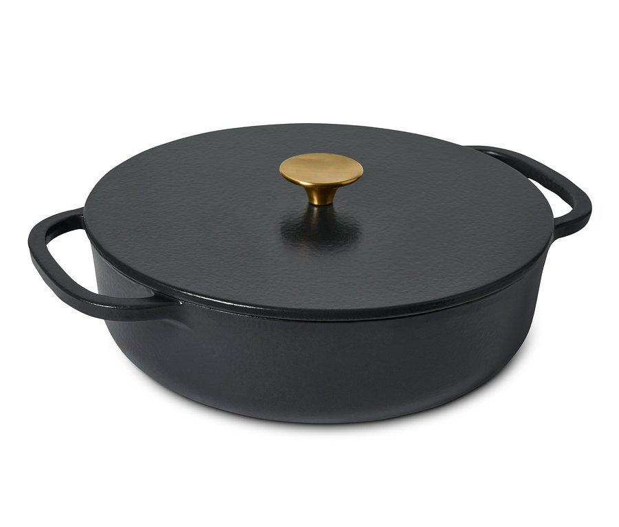 Eine schwarze Gusseisen-Bräter-Pfanne mit Deckel und goldenem Griff.