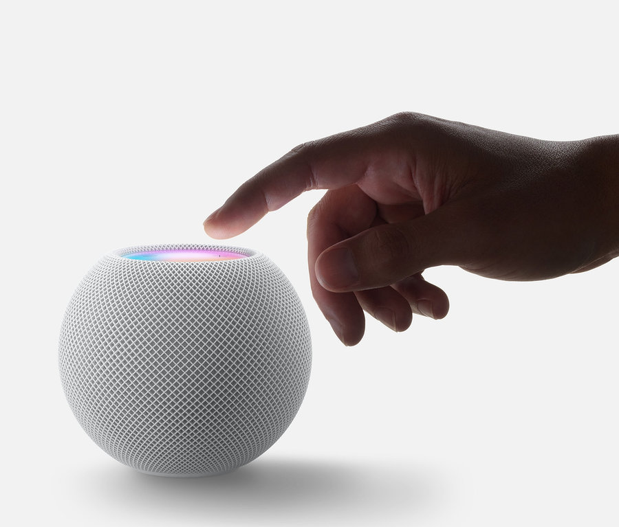Finger berührt grauen Apple HomePod mini.
