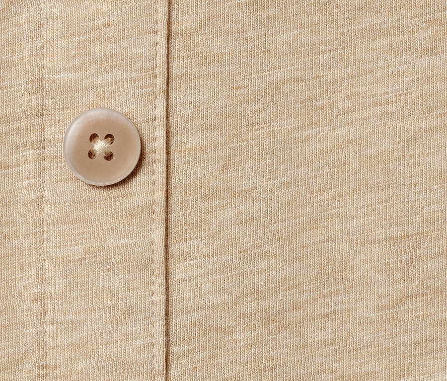 Detailaufnahme eines beigen Tops mit Knopfleiste.