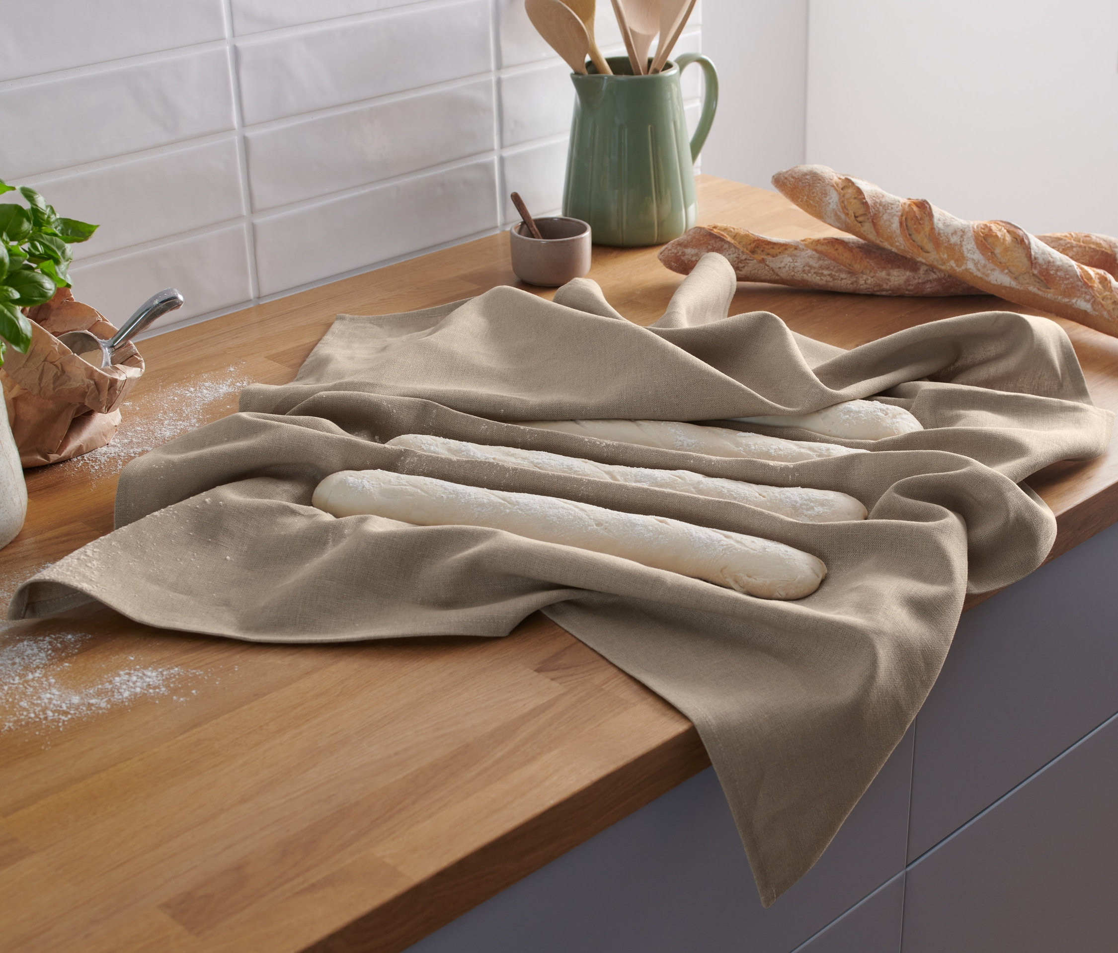 Teig für Baguettes liegt auf einem beigen Bäckerleinen.