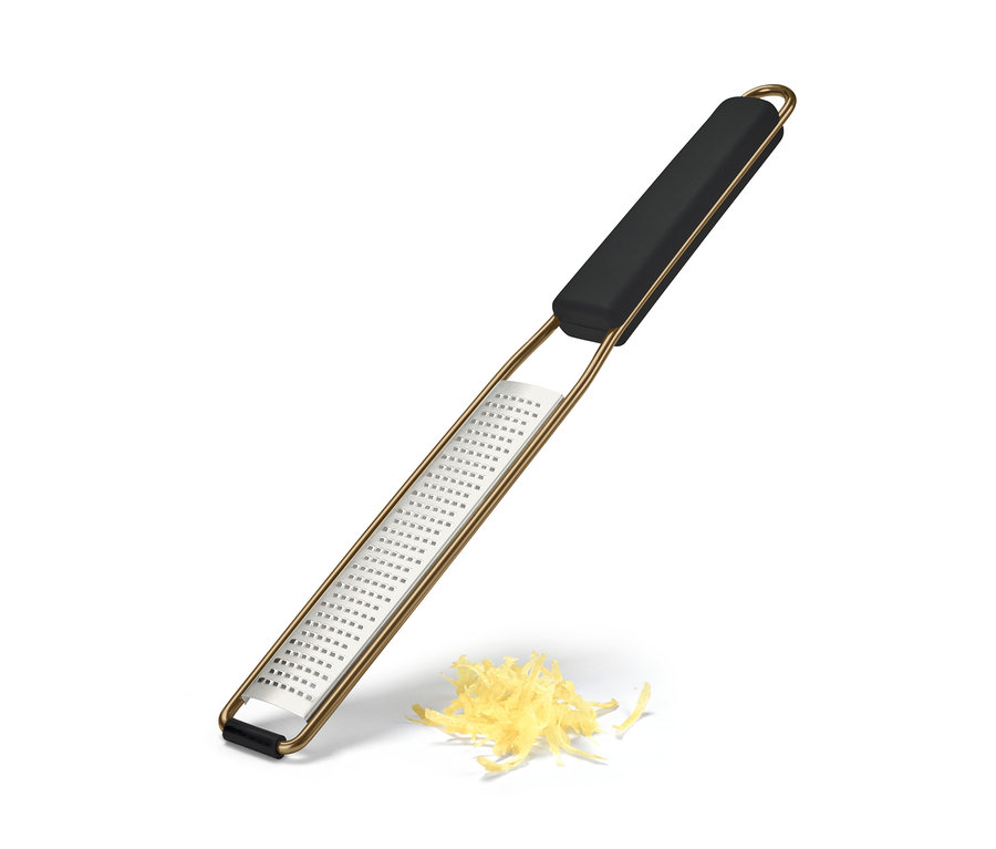 Eine feine Handreibe liegt mit geriebenem Käse auf einem weißen Hintergrund.