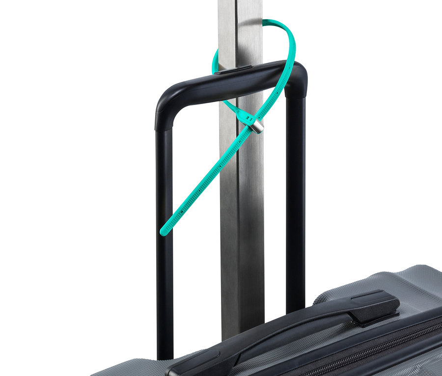 Ein türkises Kabelbinderschloss ist an einem Griff eines grauen Koffers und einer silbernen Stange befestigt.