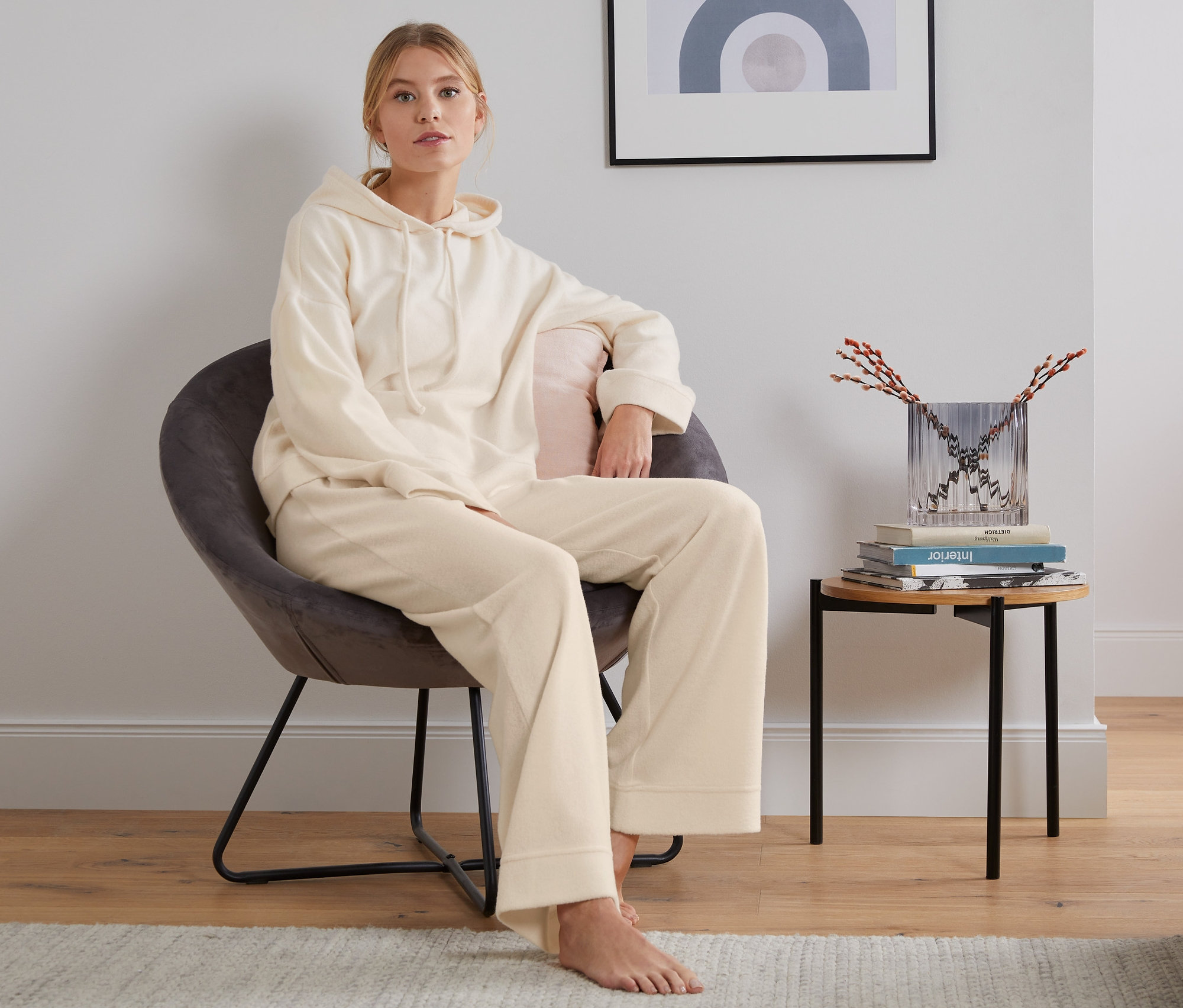 Frau sitzt im Sessel und trägt eine Fleecehose.