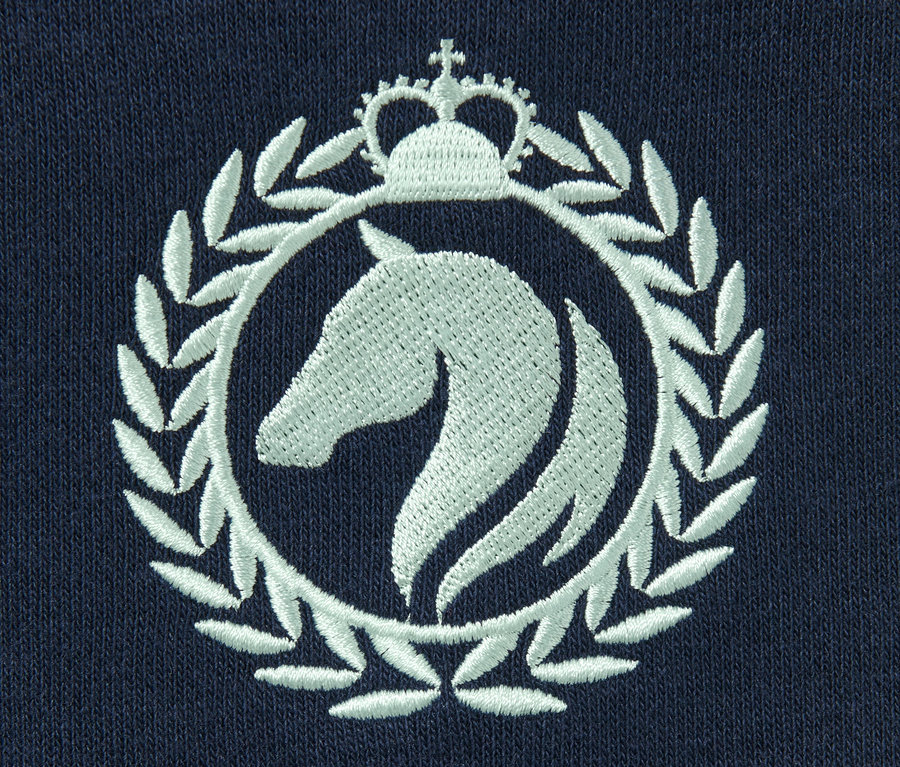 Detailansicht eines blauen Sweatshirts mit einem aufgestickten, weißen Pferde-Logo im Kreis mit einer Krone.