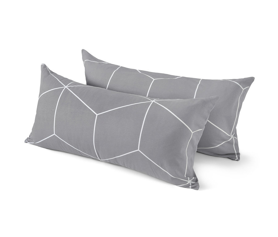 Zwei graue Kissen mit weißem geometrischen Muster liegen übereinander.