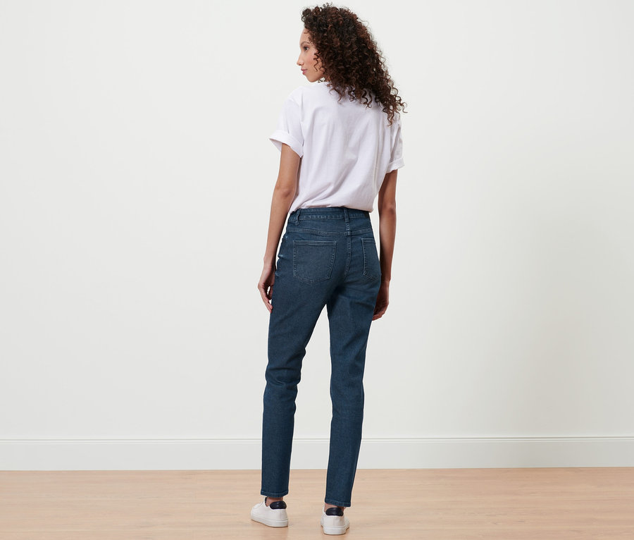 Frau von hinten in dunkelblauen Slim-Denim »Fit Emma« und weißem T-Shirt.