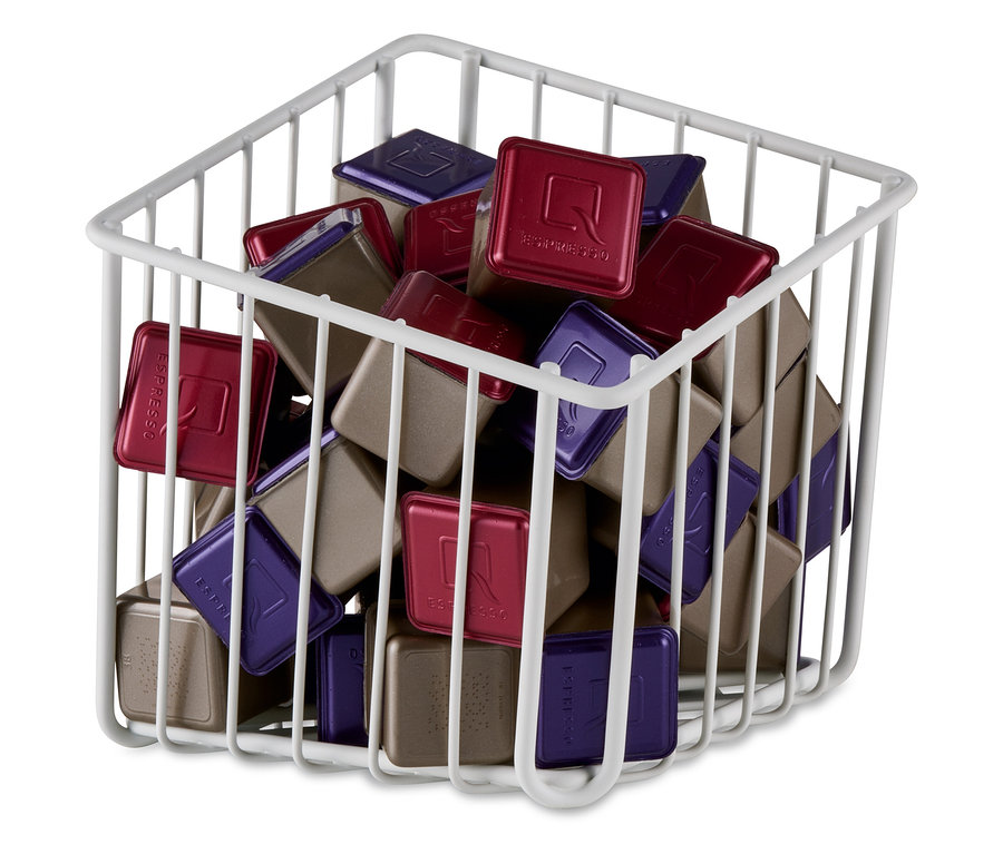 Ein weißer Kapselkorb gefüllt mit roten, violetten und braunen Kapseln.