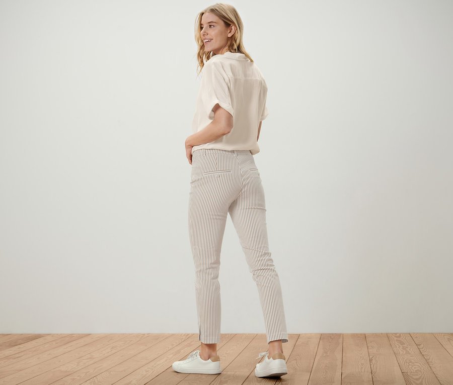 Blonde Frau blickt über die Schulter, trägt eine gestreifte Stretch-Twill-Hose.