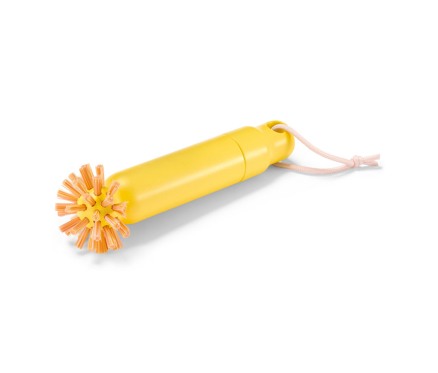 Gelbe 2-in-1-Abflussbürste mit orangefarbenen Borsten und rosa Aufhängeschnur.