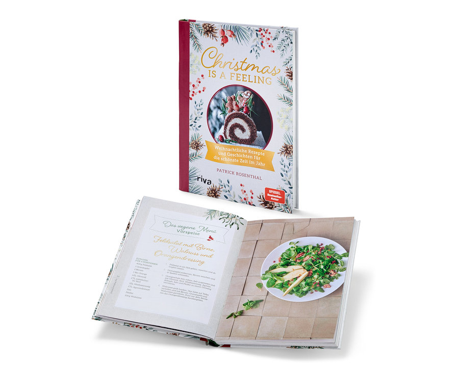 Zwei Kochbücher mit Weihnachtsmotiven. Ein Buch ist geschlossen und steht senkrecht, das andere ist geöffnet und liegt waagerecht. Zu sehen ist das Buch "Christmas is a feeling".