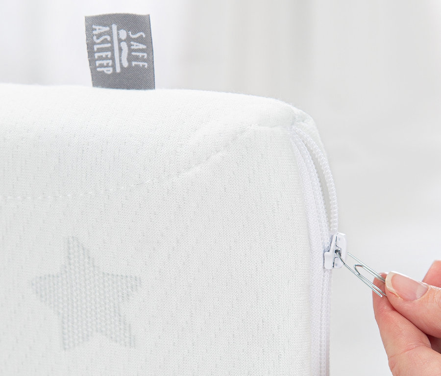 Eine Hand öffnet mit einer Büroklammer den Reißverschluss am roba 2-in-1-Beistellbett »safe asleep®«, taupe.