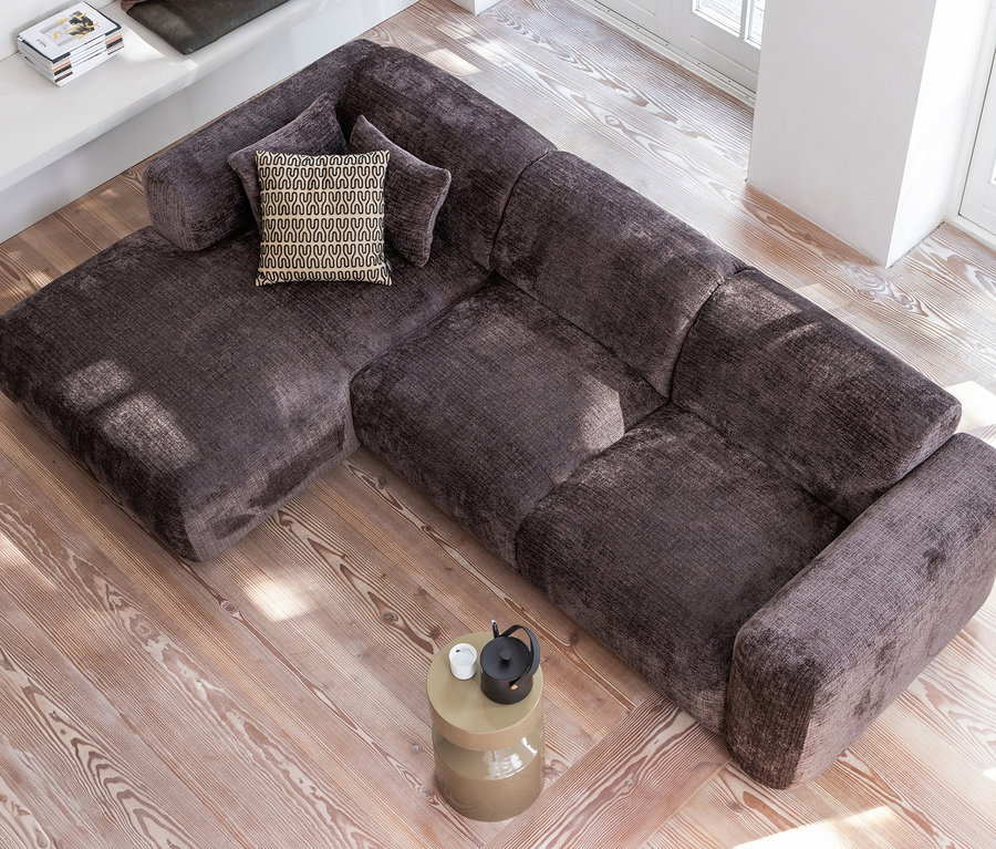 Ecksofa mit Kissen und beigem Woood Ferry Metallbeistelltisch im Wohnzimmer.