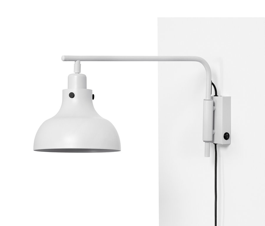 Eine Wandleuchte mit Schwenkarm aus Metall ist an einer weißen Wand befestigt.