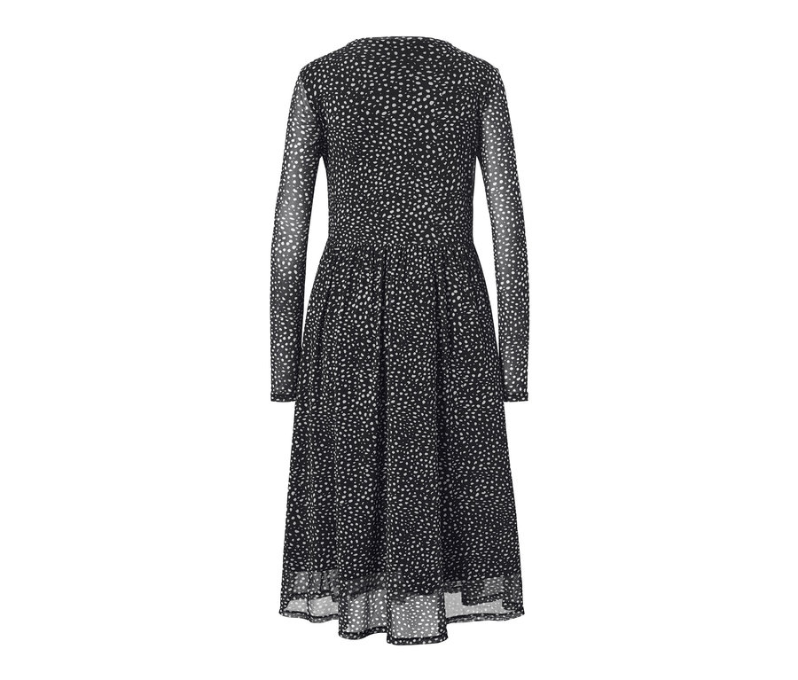 Ein gepunktetes Mesh-Kleid in Schwarz mit langen Ärmeln und einem Allover-Punktmuster in Weiss.