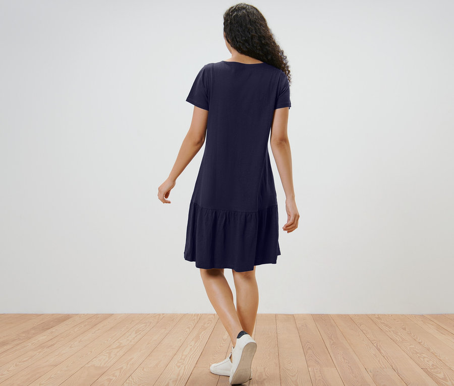 Frau von hinten in dunkelblauem Jerseykleid mit Volant.