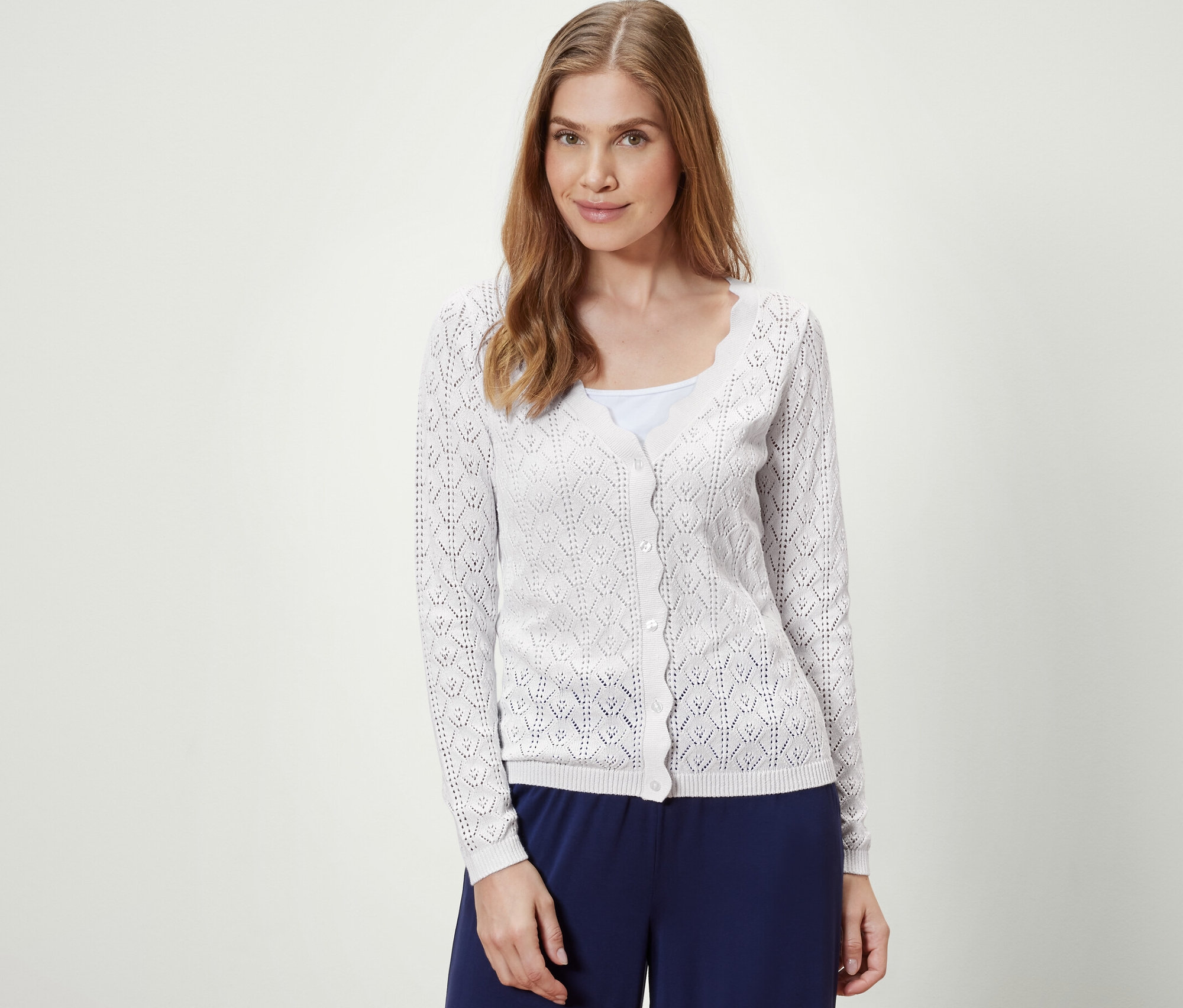 Frau trägt eine weiße Strickjacke mit Ajour-Muster.