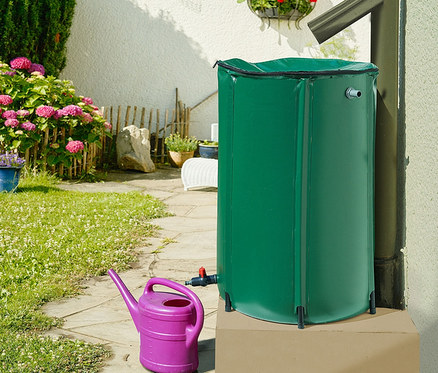 Eine grüne, faltbare Regentonne, ca. 250 l, mit einer lila Gießkanne.