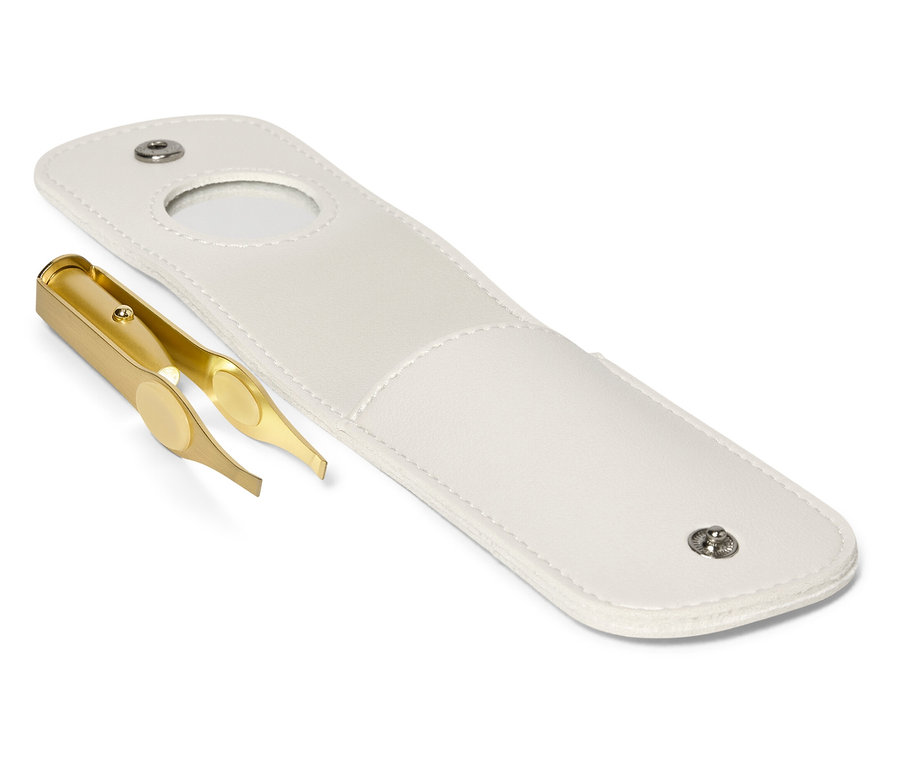 Eine goldene Pinzette liegt neben einer offenen weißen Hülle.