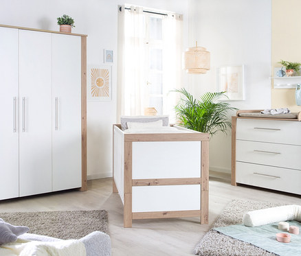 Zimmer mit weißen Kindermöbeln und Holzdetails, inklusive roba Wickelkommode »Malo«.