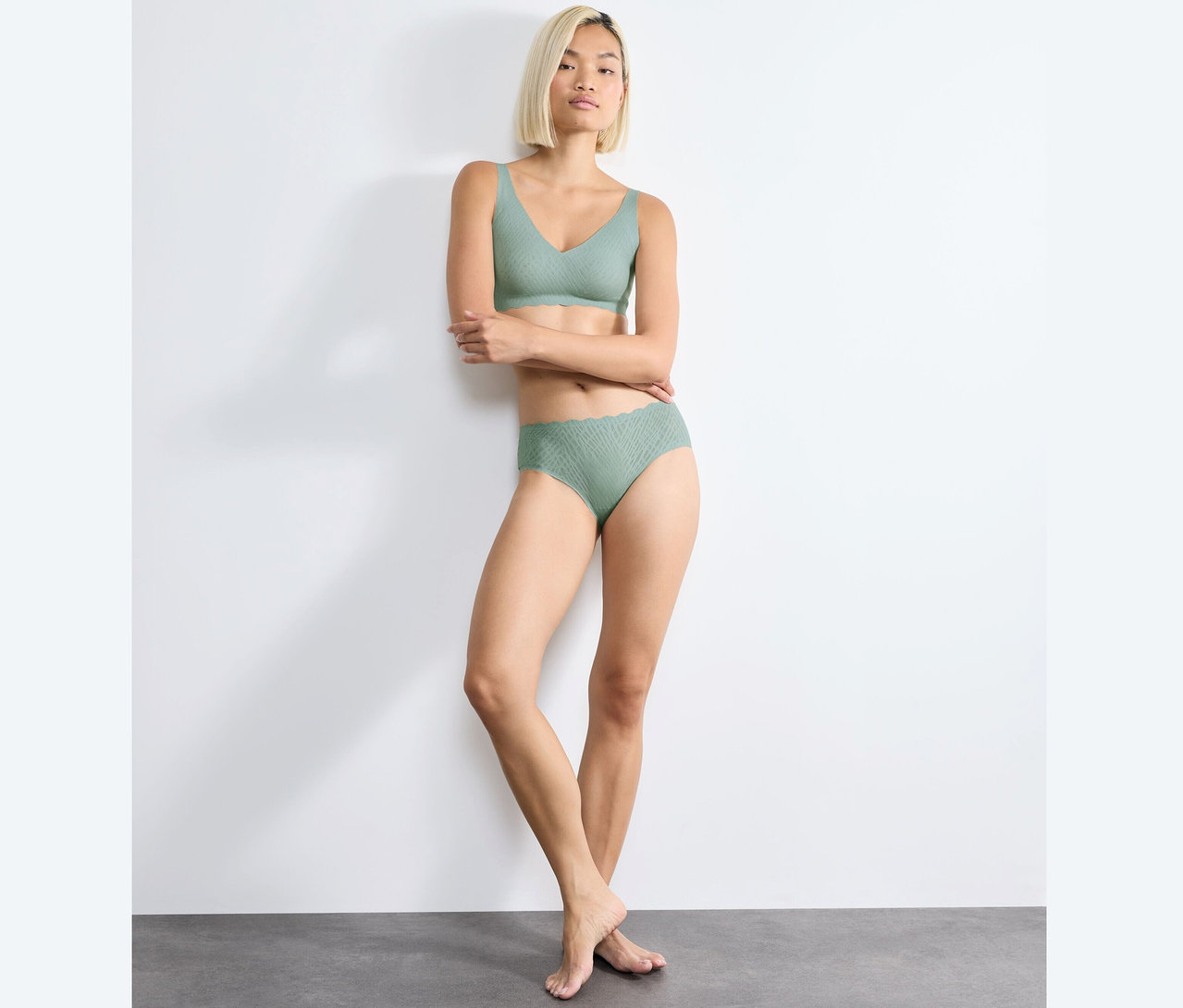 Frau posiert in sloggi ZERO Feel Bliss Soft Bra, misty turquoise und passendem Höschen.