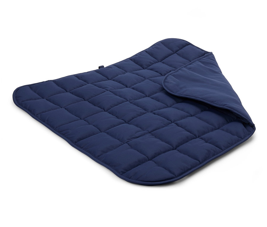 Detailansicht einer gesteppten, dunkelblauen Decke auf weißem Hintergrund.