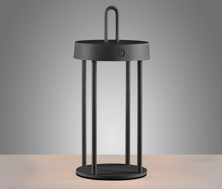 Eine schwarze JUST LIGHT LED-Akku-Tischleuchte »Anselm« steht auf einer hellen Oberfläche.