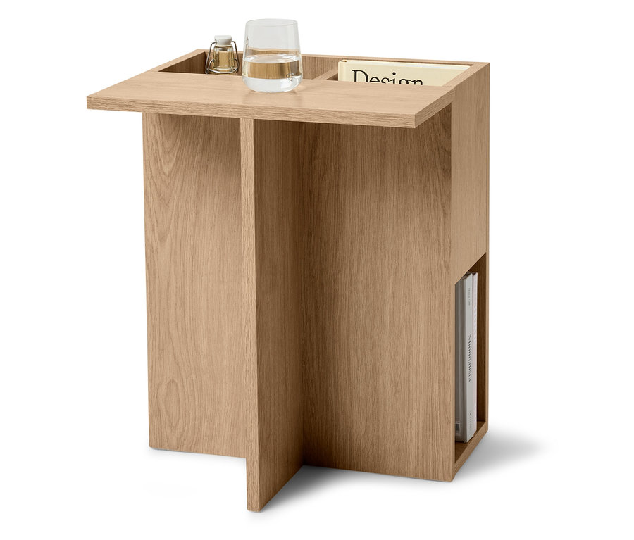 Beistelltisch aus hellem Holz mit Wasserglas, Lampe und Zeitschrift.