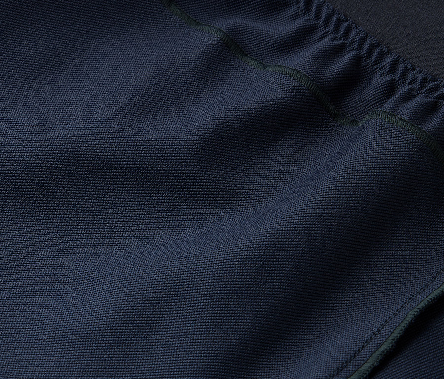 Detailaufnahme einer marineblauen Stofftextur mit Kordelzug oben.