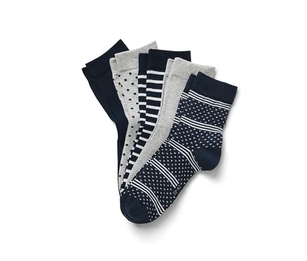 Fünf Paar Socken mit verschiedenen Mustern liegen übereinander.