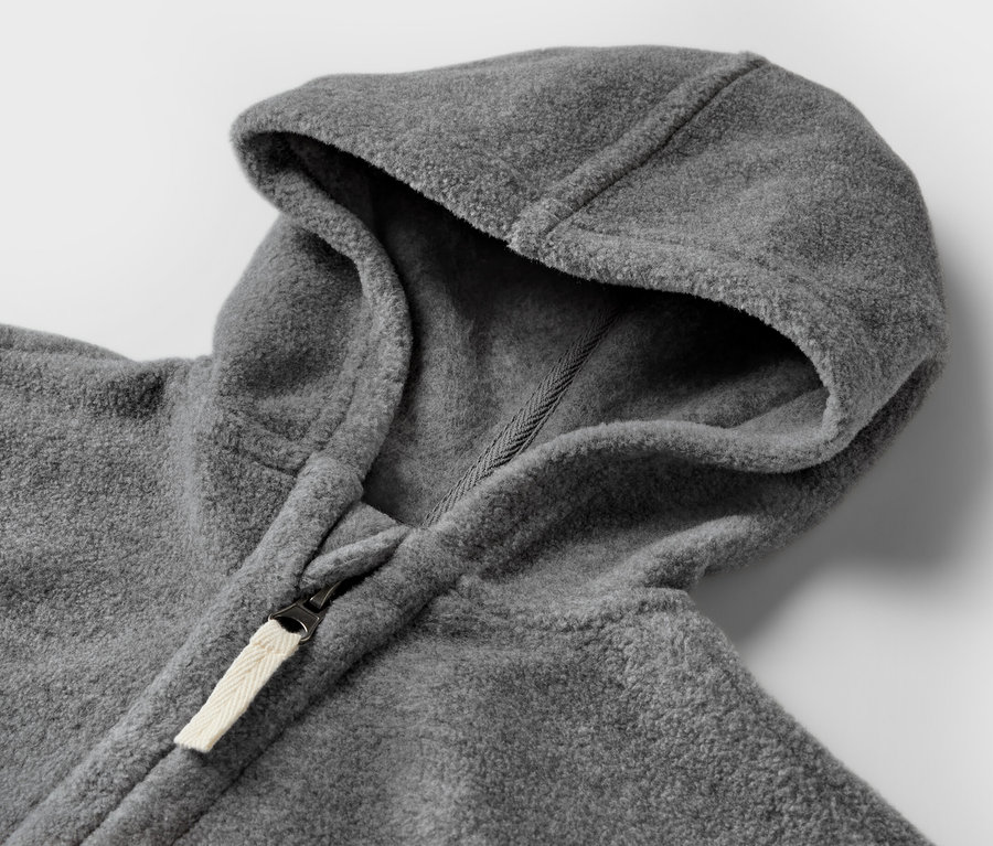 Detailaufnahme einer grauen Baby-Fleecejacke mit Kapuze und Reißverschluss.