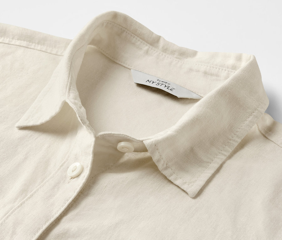 Detailansicht einer cremeweißen Leinenbluse.