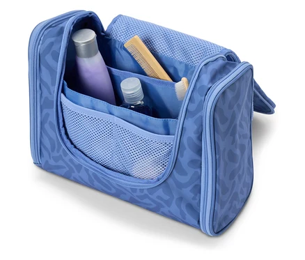 Offene, hellblaue Kosmetiktasche mit verschiedenen Reiseutensilien wie Shampoo, Kamm und Zahnbürste.