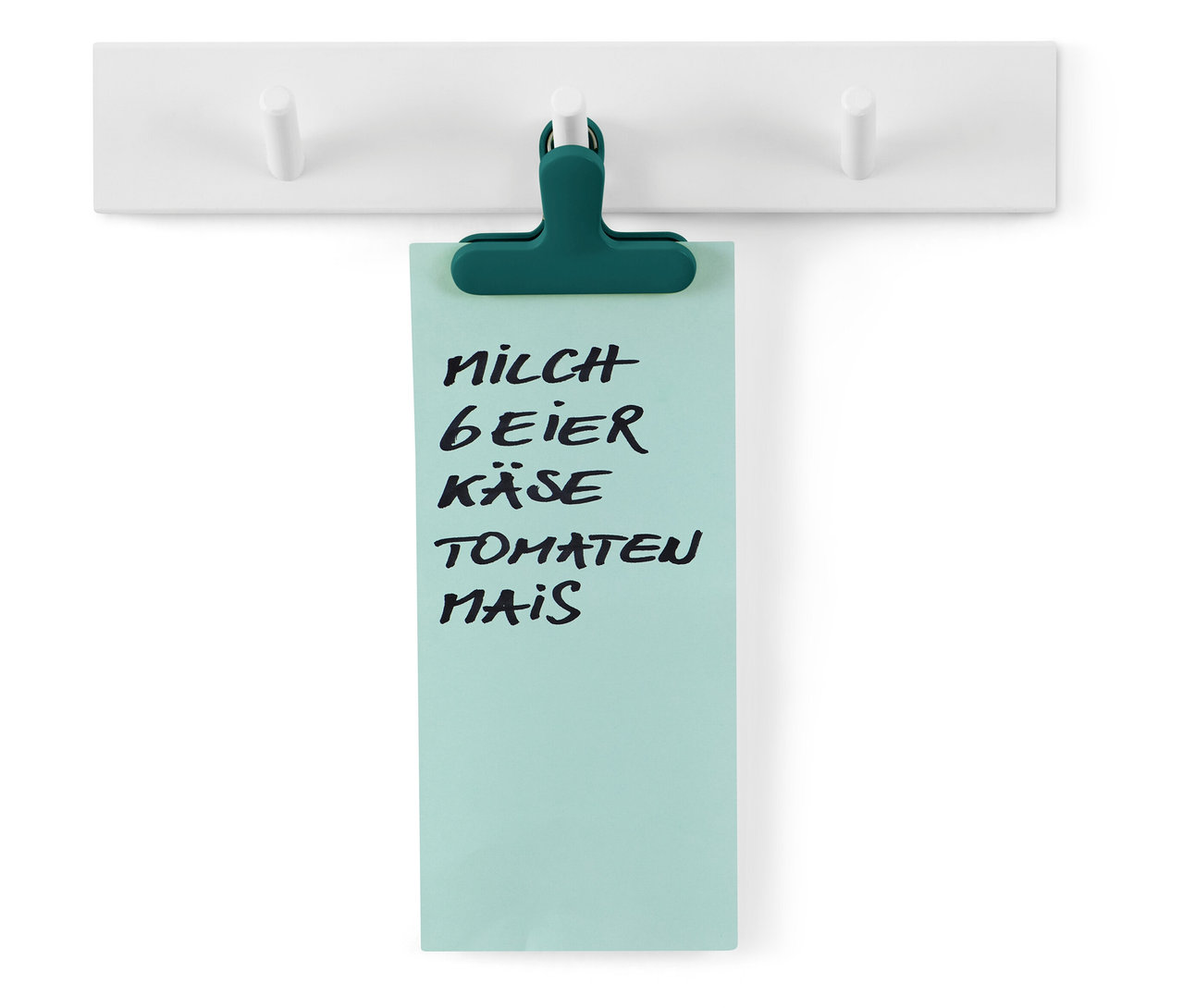 Einkaufszettel hängt an einer weißen Hängeleiste mit drei Haken, befestigt mit einer grünen Klammer.