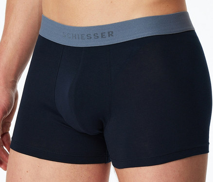 Ein Mann trägt dunkelblaue SCHIESSER Slipboxer mit grauem Bund.