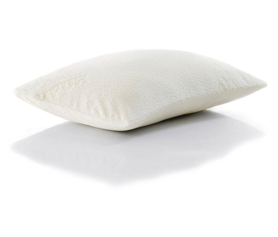 Ein einzelnes, elfenbeinfarbenes Kissen liegt auf einer weißen Oberfläche und wirft einen leichten Schatten.