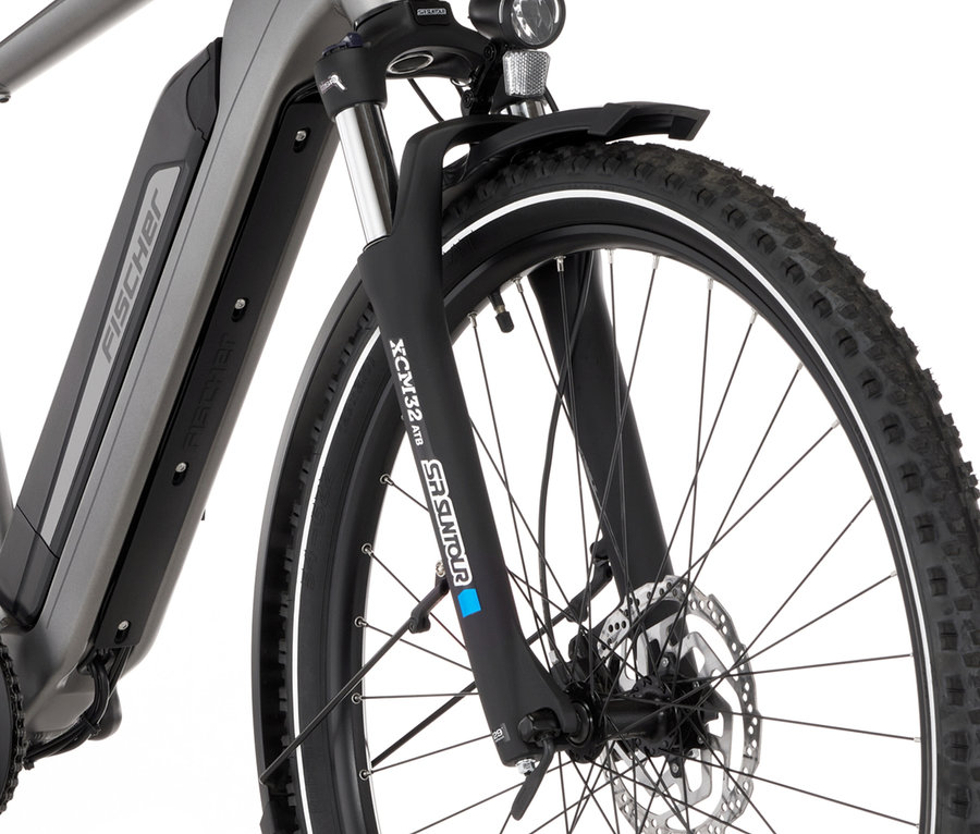 Nahaufnahme des Vorderreifens und der Federgabel eines grauen FISCHER Trekking-E-Bikes TERRA 2.2 ACTIVE (Diamant Rahmen).