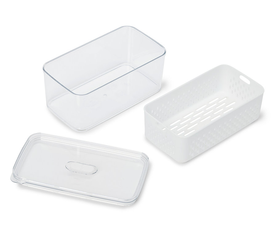 Ein durchsichtiger Behälter, ein weißer perforierter Behälter und ein durchsichtiger Deckel liegen auf einer weißen Oberfläche.