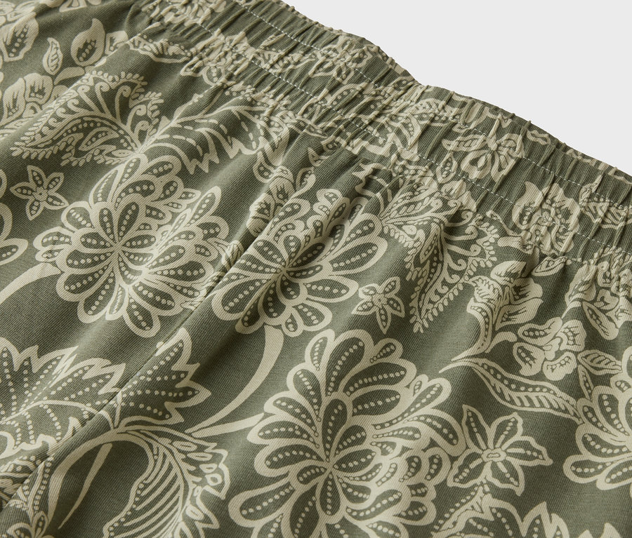 Nahaufnahme des elastischen Bundes einer Hose mit Blumenmuster in Grün und Beige.
